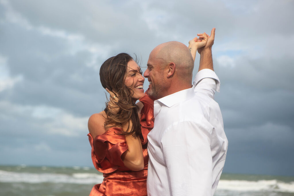 Couple smiling and gazing into each other’s eyes during romantic engagement session at Blowing Rocks Preserve in Florida.