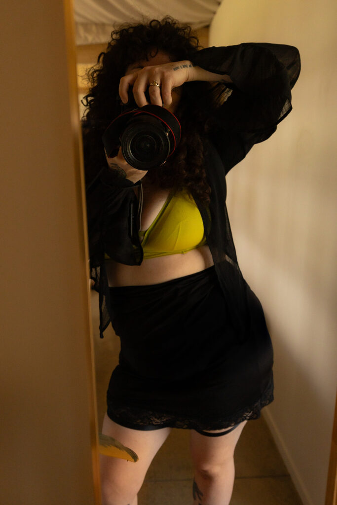 Cecelia takes a mirror selfie with her Canon professional camera while wearing a boudoir outfit, capturing her bold and confident presence during her New Zealand destination shoot.