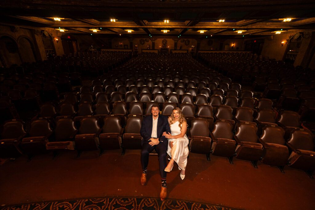 Bride and Groom engagement Photos sitting in the Tampa Theatre Seats.