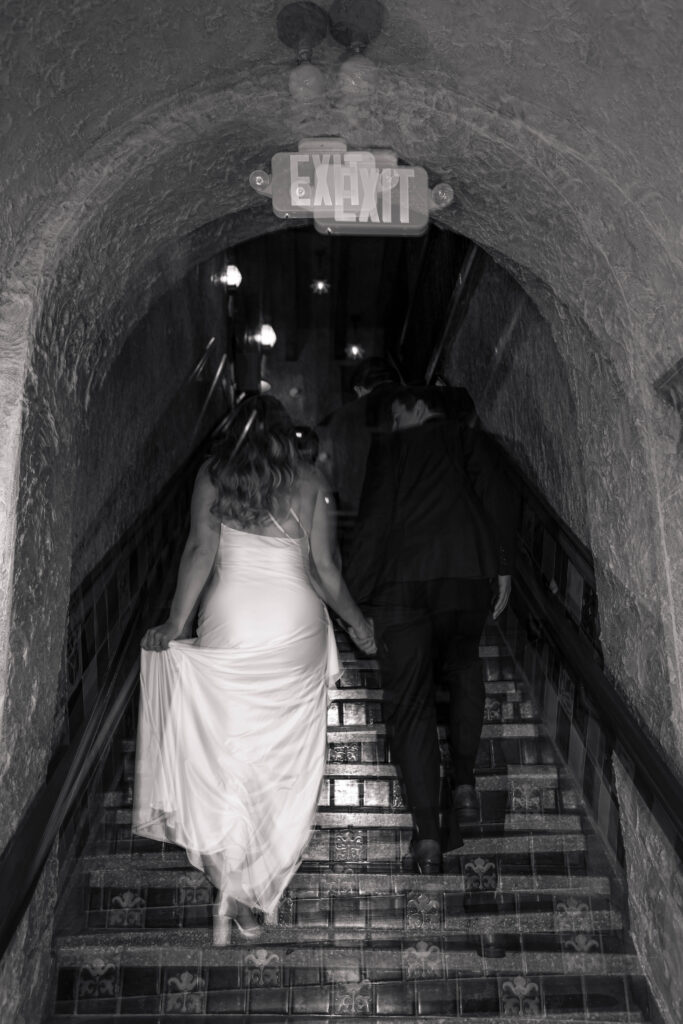 Raichel and Drake photographed by CeceTay Productions at the Tampa Theatre holding hands as bride and groom.