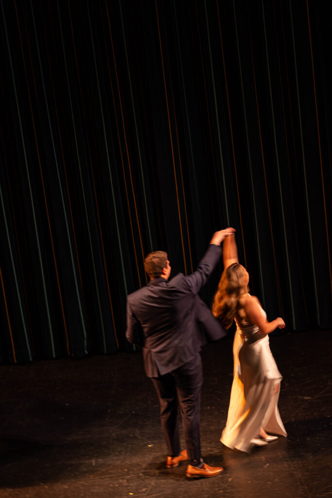 Raichel and Drake dancing as bride and groom on the stage of the tampa theatre for their engagement session with CeceTay Productions Tampa