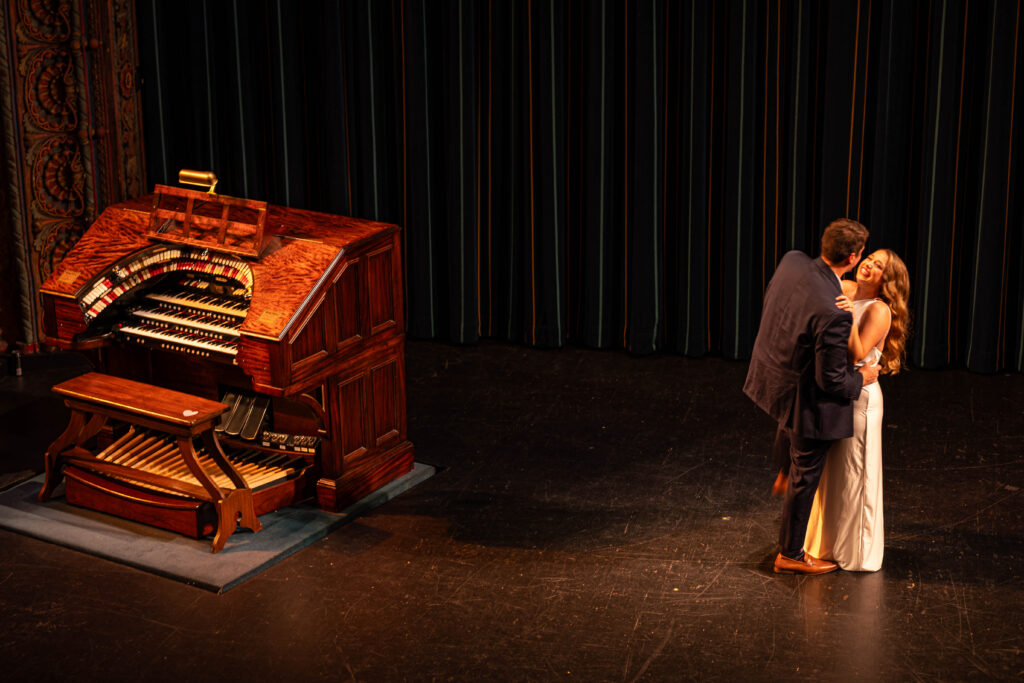 Couple dancing on the stage at the tampa theatre during their engagement session with cecetay productions.