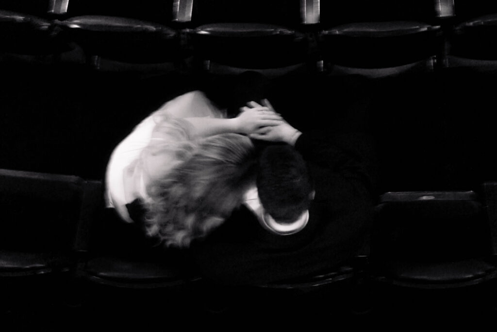 Couple in seats cuddling before movie at the tampa theatre for engagement session with CeceTay Productions photo & video