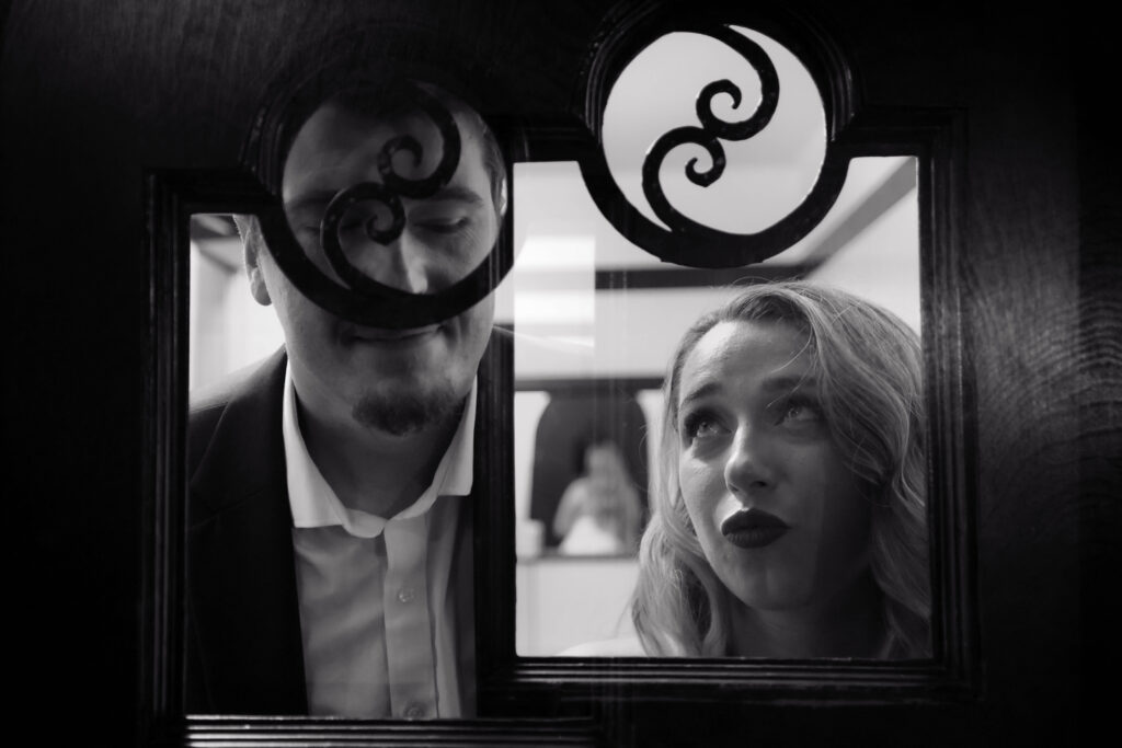 Black and white photo or couple in the bathroom of the Tampa Theatre for their engagement session with CeceTay Productions Tampa Photographer and engagement videographer.